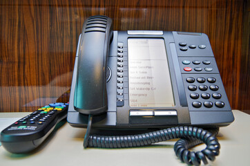 Close up of modern technology digital telephone on night stand inside suite, cabin or stateroom on...