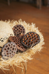 Dried lotus seed pods on brim straw hat in the interior.