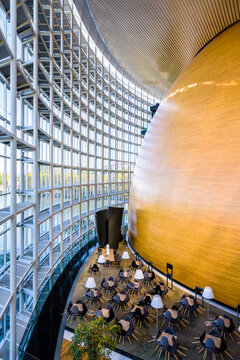 Strasbourg, France - September 13, 2019: The outside of the egg-shaped room housing the hemicycle of the European Parliament and a cafe terrace on the glass wall side in the Louise Weiss building.
