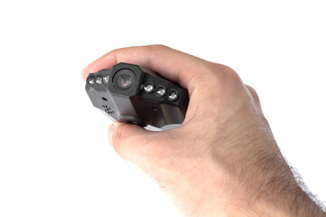 Male hand holds a black car DVR with a folding screen in the off state close up isolated on a white background