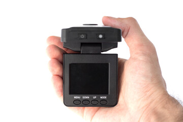 Male hand holds a black car DVR with a folding screen in the off state close up isolated on a white background