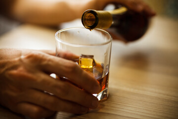 Hand with a glass of alcohol. The problem of alcoholism.