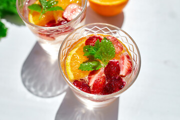 Summer cocktail with strawberry, orange and mint in glass
