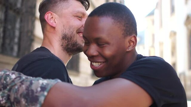 Caucasian man and African American man greet each other smiling and hugging. Brotherhood and Equality Concept. Black lives matter, stop racism