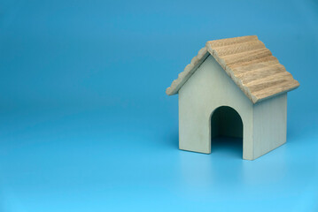 Obraz na płótnie Canvas Selective focus of miniature wooden house isolated on a blue background with a copy space.