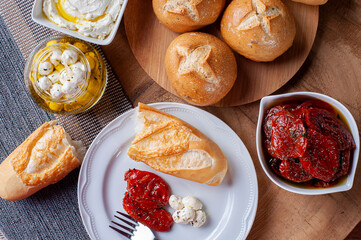 .Table with different appetizers. Assorted breads, sun-dried tomatoes, two types of curds.