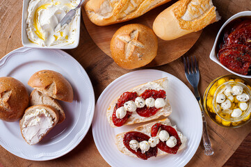 .Table with different appetizers. Assorted breads, sun-dried tomatoes, two types of curds.