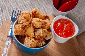 .Squares of tapioca and cheese served with pepper jelly. Wooden table. Selective focus
