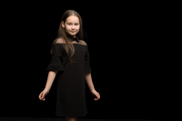 Close-up.Portrait of a cute little girl on a black background.