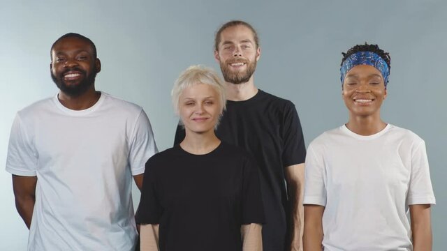 Group of people looking at camera tearing tape from mouth smiling on grey background human shut silence face fear expressive attitude taboo censorship violence scared slow motion