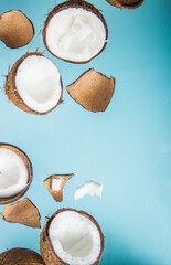 Halves of coconut, open  cut in half isolated on blue background. Coconut pulp is very healthy wholesome food. Top view, copy space, place for text.