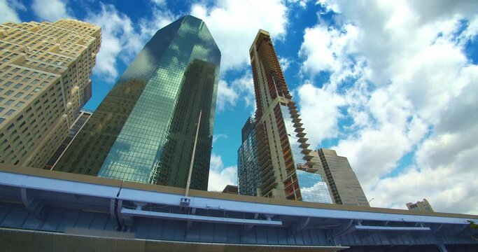 New York City skyline, pan over corporate skyscrapers, roadway, clouds blue sky 