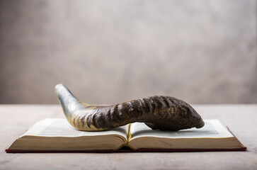 Rosh Hashanah (Hashana) (jewish New Year holiday) concept with Ram shofar (horn) with religious holy prayer book on table - obrazy, fototapety, plakaty