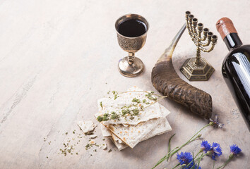 Pack of matzah or matza, Passover Haggadah and Kosher red wine, shofar-horn on a concrete...