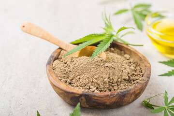 Hemp flour  in wooden spoon and hemp essential oil.  Copy space. CBD cannabis.