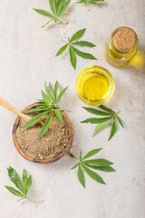 Hemp flour  in wooden spoon and hemp essential oil.  Copy space. CBD cannabis.