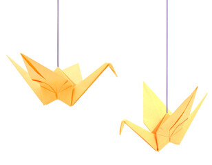 Two yellow origami cranes haning isolated white