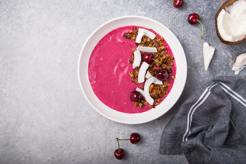 Pink Smoothie from Banana and cherry  Granola and Coconut Shreds on top. Healthy summer breakfast, top view