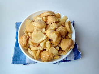 Aleurites moluccanus or Indonesian Candlenuts called Kemiri, inside a bowl, isolated in white background