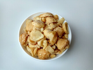 Aleurites moluccanus or Indonesian Candlenuts called Kemiri, inside a bowl, isolated in white background