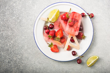 Berry Popsicle with wooden sticks on concrete counter. Homemade Strawberry Frozen Fruit Bars