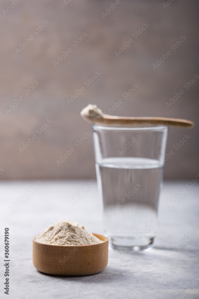 Wall mural glass of water, collagen powder on white table. healthy lifestyle concept. copy space