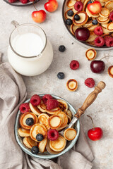 Bowl with mini pancake cereal with raspberries, mint and blueberries.Tasty breakfast