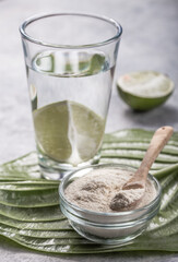 Collagen Powder and glass of water with  slice of Lime; Vitamin C . Collagen supplements may improve skin health by reducing wrinkles and dryness.