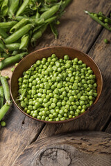 Young fresh green peas on wooden  table viewed from above
