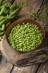 Young fresh green peas on wooden  table viewed from above
