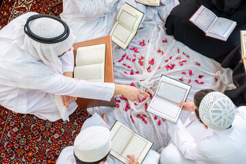 Happy arabic family reading and learning quraan during ramadan