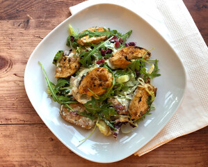 Grilled chicken fillets strip on mixed greens salad and yogurt dressing.  Classic summer dish.