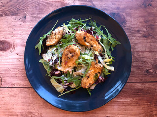 Grilled chicken fillets strip on mixed greens salad and yogurt dressing.  Classic summer dish.