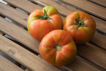 three large tomatoes together placed on the table