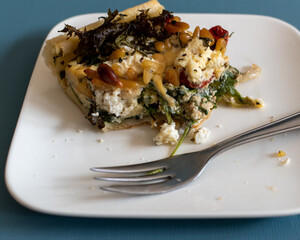 half eaten slice of Mediterranean quiche with feta and olives 