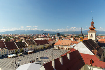 SIBIU, ROMANIA - Circa 2020: High view of old medieval town with cloudy blue sky. Beautiful tourist spot in eastern central Europe. Aerial view of famous Big Square in Sibiu Romania