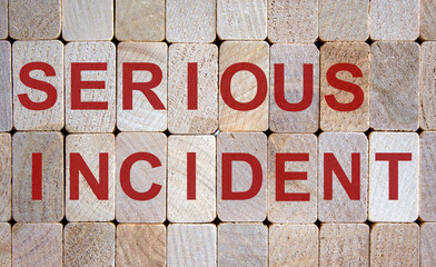 Wooden blocks form the words 'serious incident'. Beautiful wooden background.