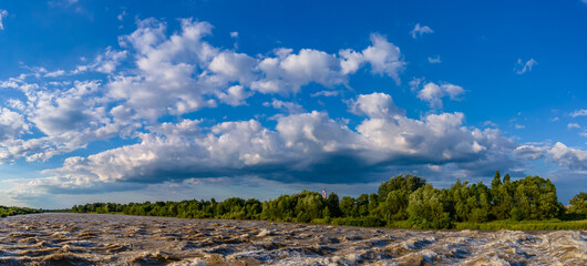 panorama with a rough river and cloudy sky