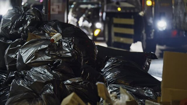 Plastic bags garbage pile, New York City street by night, dump disposal heap
