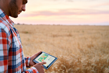 Precision farming. Farmer hands hold tablet using online data management software, differential...