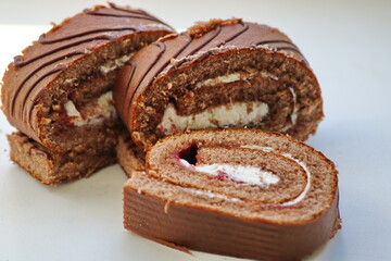 Cherry roll with white, whipped, cream cream on a white background, close-up