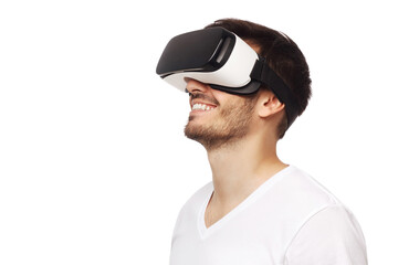 Young happy man smiling while enjoying and experiencing virtual reality with VR headset, isolated on white background