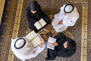 Top view of muslim family members reading quraan together