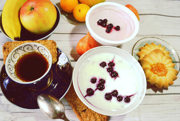 Healthy protein- and vitamin-rich breakfast on the table with Chicory cup,  vanilla chia pudding made of skim milk, apple, apricots, banana, pear, skyr with blueberries, cereal cookies. Closeup