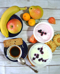 Healthy protein- and vitamin-rich breakfast on the table with Chicory cup,  vanilla chia pudding made of skim milk, apple, apricots, banana, pear, skyr with blueberries, cereal cookies. 