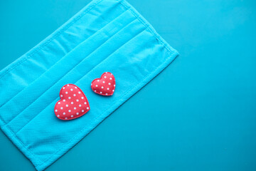 Surgical masks with heart shape on green background 
