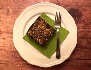Chocolate brownie with nuts on wooden background.