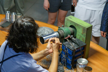 Obraz premium KUALA LUMPUR, MALAYSIA - CIRCA 2018: Tourists visit the production process of kitchenware,jewelry accessories from tin ore mixed with antimony and copper called Pewter. This factory is named Rayal Sal