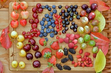 a variety of fresh berries on a wooden background
