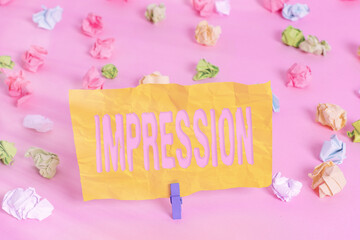Handwriting text writing Impression. Conceptual photo an idea and feeling or opinion about something or someone Colored crumpled papers empty reminder pink floor background clothespin